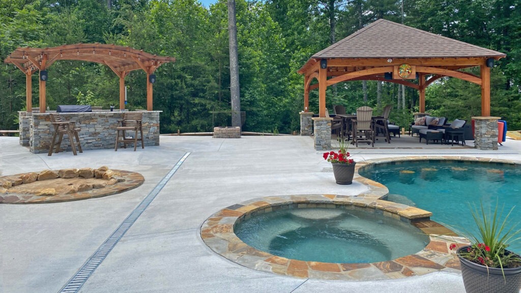 Poolside pergola and gazebo with stone accents, firepit, and outdoor lounge seating.
