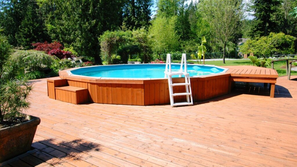 Rustic wooden above-ground pool deck with ladder, garden background, and warm brown finish.