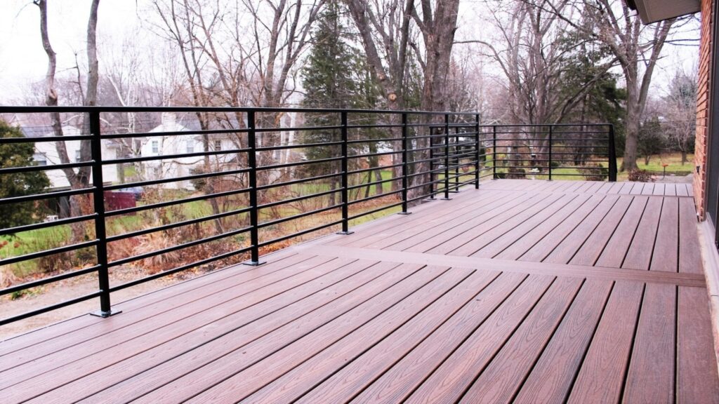 Black horizontal aluminum deck railing with brown composite decking and modern minimalist style.