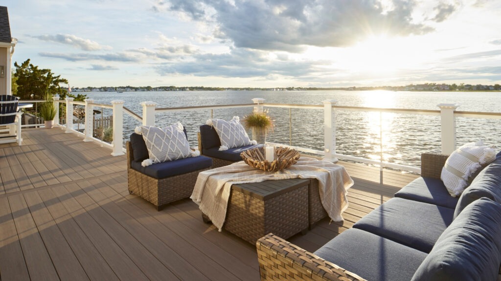 TimberTech AZEK Coastline deck overlooking water with sleek modern furniture and railing.