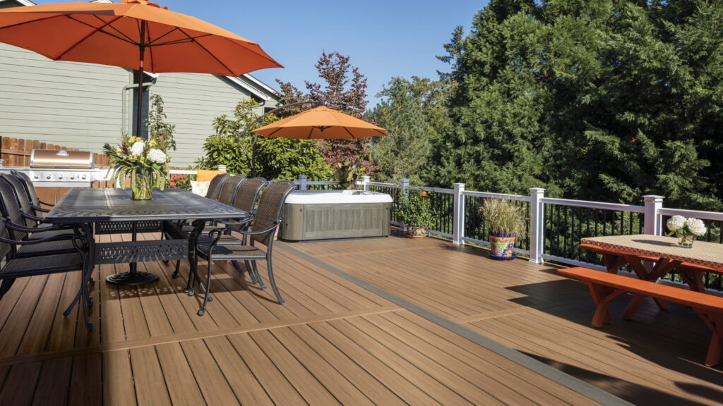 Two-tone TimberTech deck in Coconut Husk with Sea Salt Gray border and orange umbrellas.