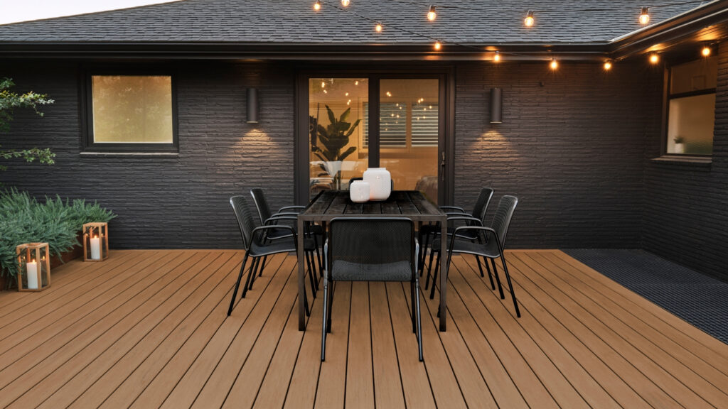 TimberTech Coconut Husk deck with black home exterior, dining set, and string lights.