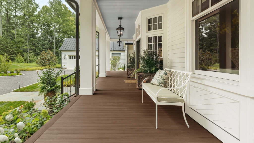 TimberTech English Walnut porch deck with white railing and countryside landscape.