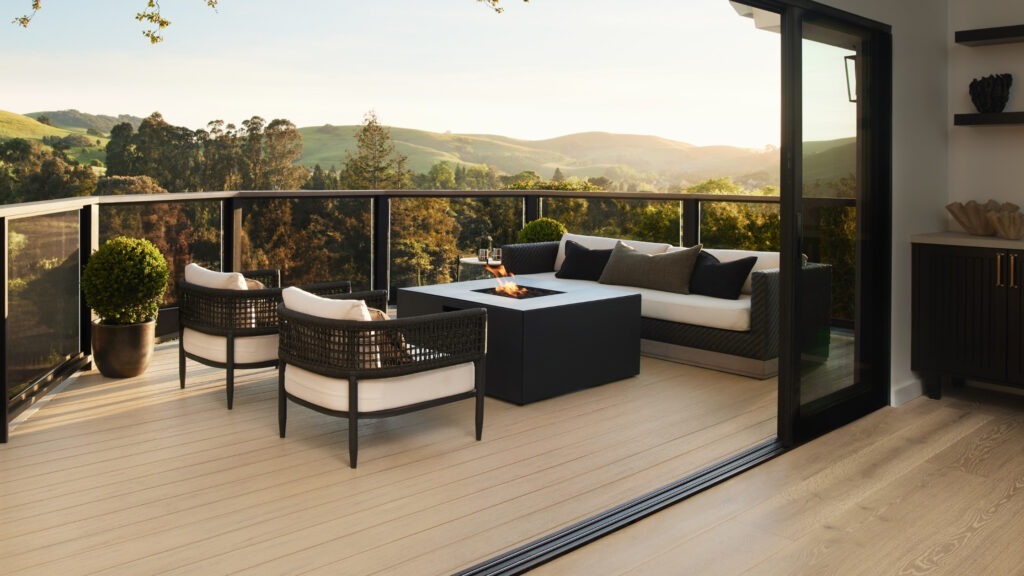 TimberTech Reclaimed Chestnut deck with glass doors and mountain valley background.