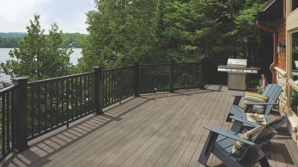 TimberTech Vintage Dark Hickory deck with black rail and lake view surrounded by trees.