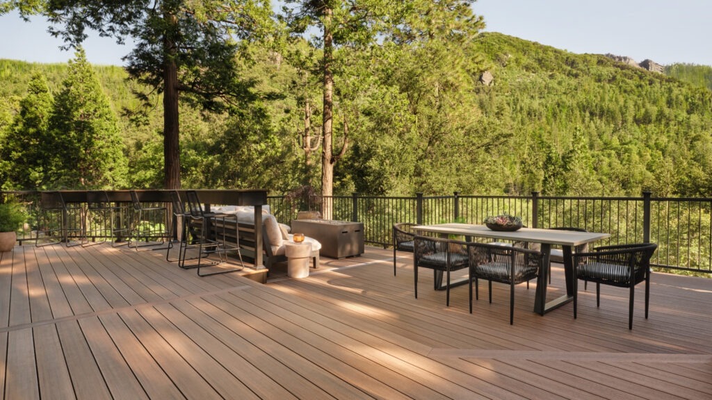 TimberTech Vintage English Walnut deck with black railing and forest mountain background.