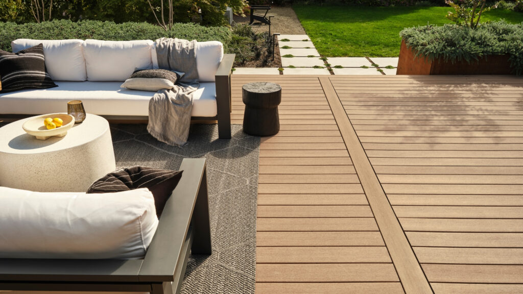 TimberTech Weathered Teak Vintage Collection deck with modern lounge furniture and garden view.