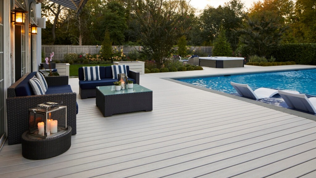 TimberTech Legacy Whitewash Cedar deck beside pool with navy outdoor furniture.