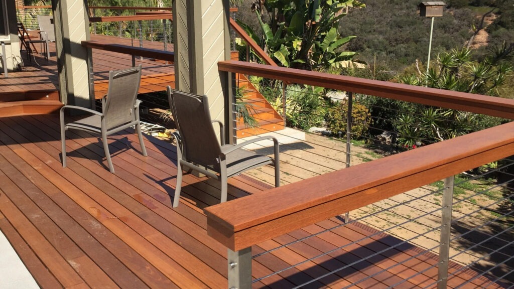 Tropical hardwood deck with stainless steel cable railing and lounge chairs, outdoor cable deck railing ideas.
