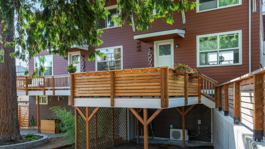 Modern horizontal cedar wood deck railing with warm tone slats for elevated backyard deck.