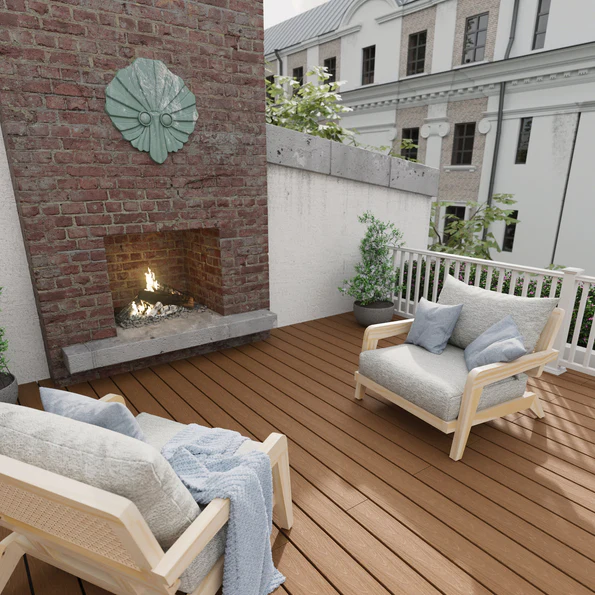 A cozy outdoor seating area is built with Veranda Timber Brown decking, creating a warm and inviting foundation beneath lounge chairs. The rich brown tone complements the surrounding brick accent wall and neutral furnishings. The setting feels comfortable and welcoming, perfect for relaxing or entertaining outdoors.