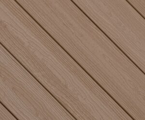 Close-up swatch of Envision Ridge Premium Sandstone composite decking highlighting a light tan color with soft grain variation for a clean, neutral wood look.