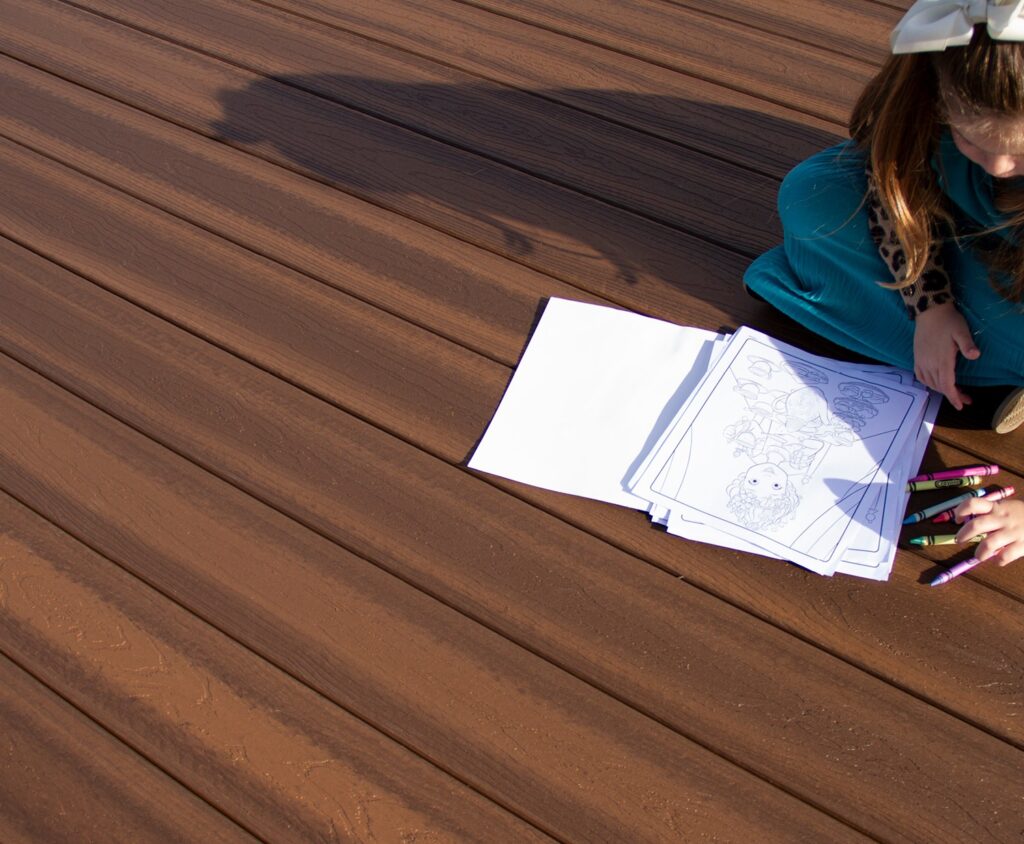 Ridge Premium Vintage Oak decking installed on a lakeside deck, featuring rich wood-inspired color and natural-looking grain that complements outdoor seating and scenic views.