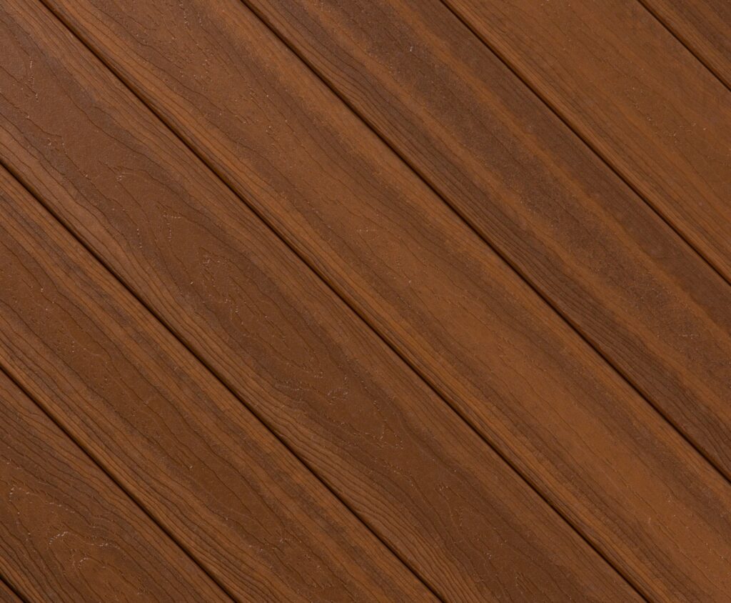 Close-up swatch of Envision Ridge Premium Vintage Oak composite decking featuring warm golden-brown tones with subtle grain pattern inspired by aged oak planks.