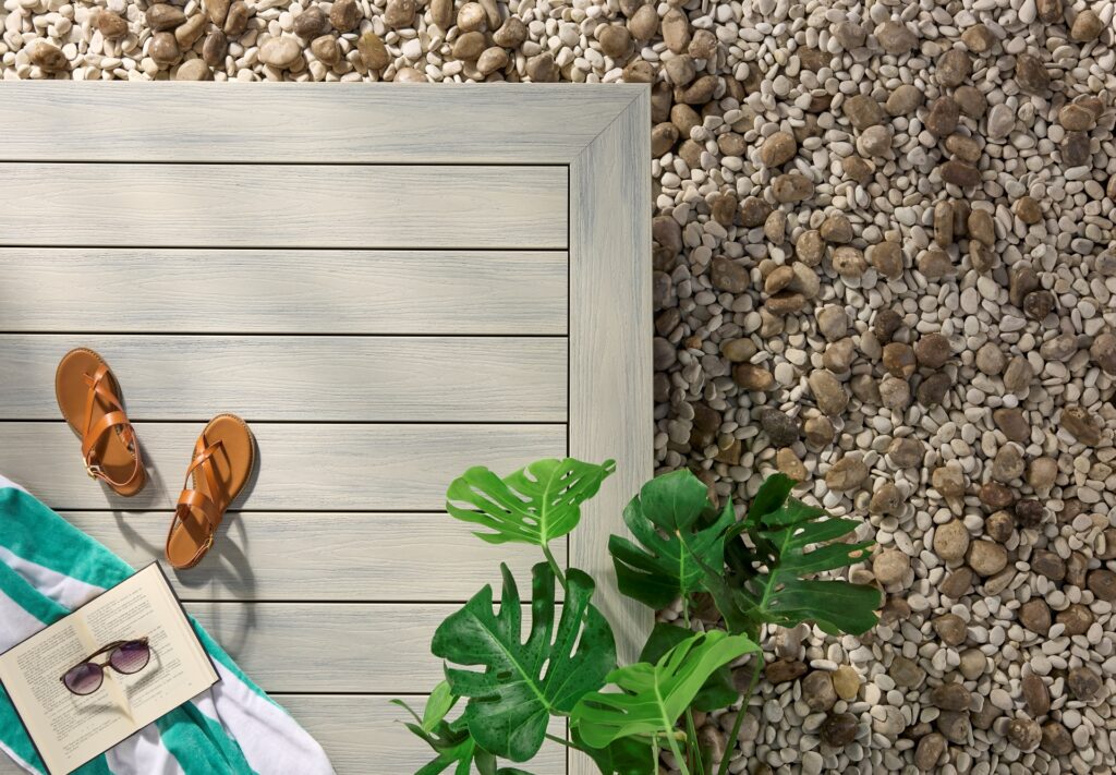 Wolf Haven Wheatfield cellular PVC decking installed in a relaxed outdoor space, featuring soft wheat-toned boards with subtle gray grain variation, clean picture framing, and a light, coastal-inspired deck layout.
