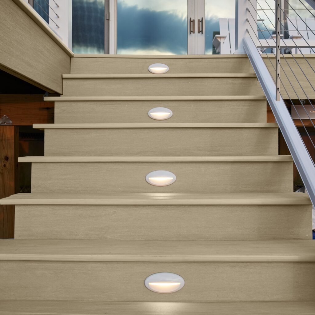 TimberTech Premier+ Natural Oak composite decking stairs with integrated step lighting, showcasing straight-grained hardwood look and moisture-resistant capped composite construction.