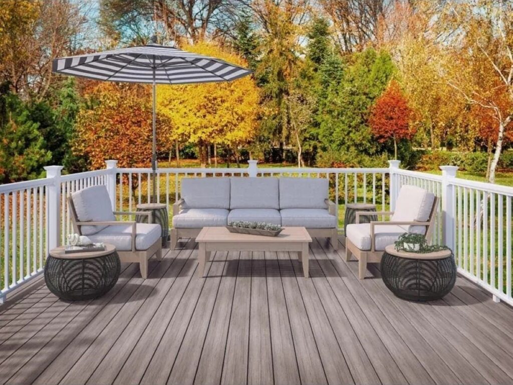 Deckorators Pioneer Fieldstone Grey decking installed on an outdoor deck with white railing and patio furniture, showcasing a modern grey tone and clean board layout.