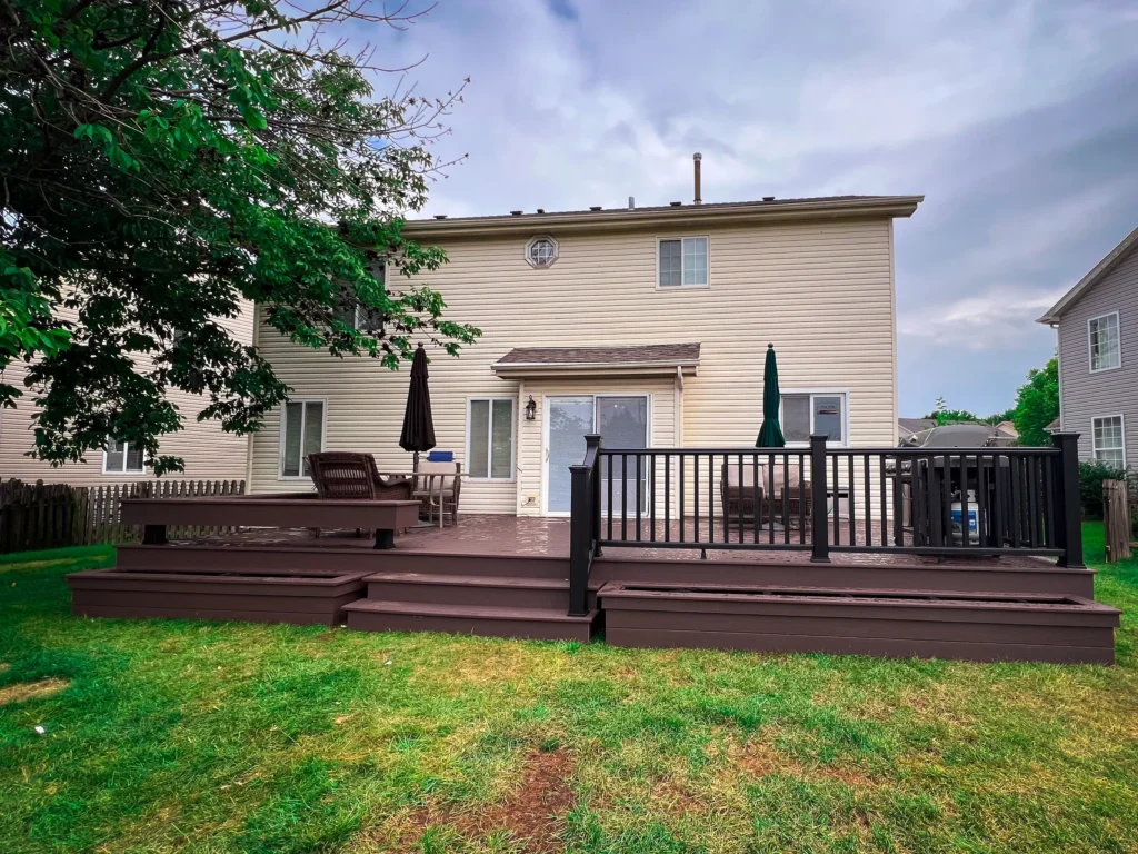 Backyard composite deck with black aluminum railing installed by Griffith Decking deck builder near Plainfield Illinois.