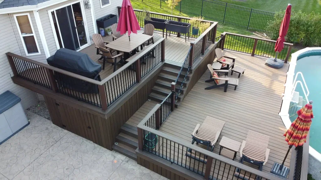 Elevated composite deck with outdoor dining area and black aluminum railing installed by Mitchell Construction Custom Decks deck builder near Plainfield Illinois.
