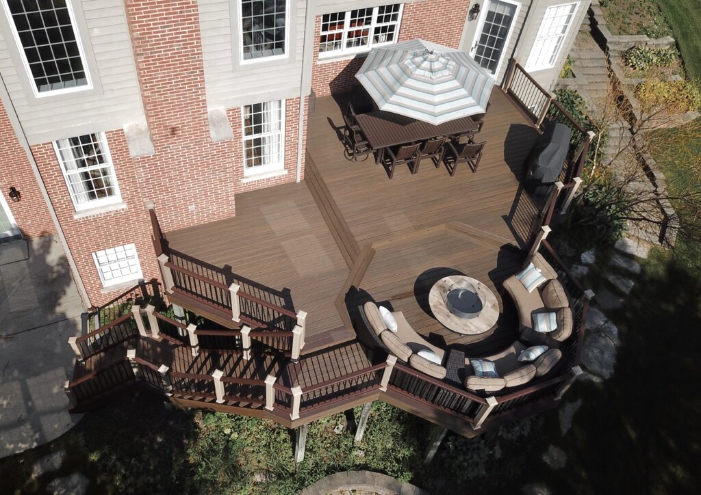 Multi-level composite deck with outdoor dining and fire pit space built by Platinum Decking serving Plainfield IL homeowners.
