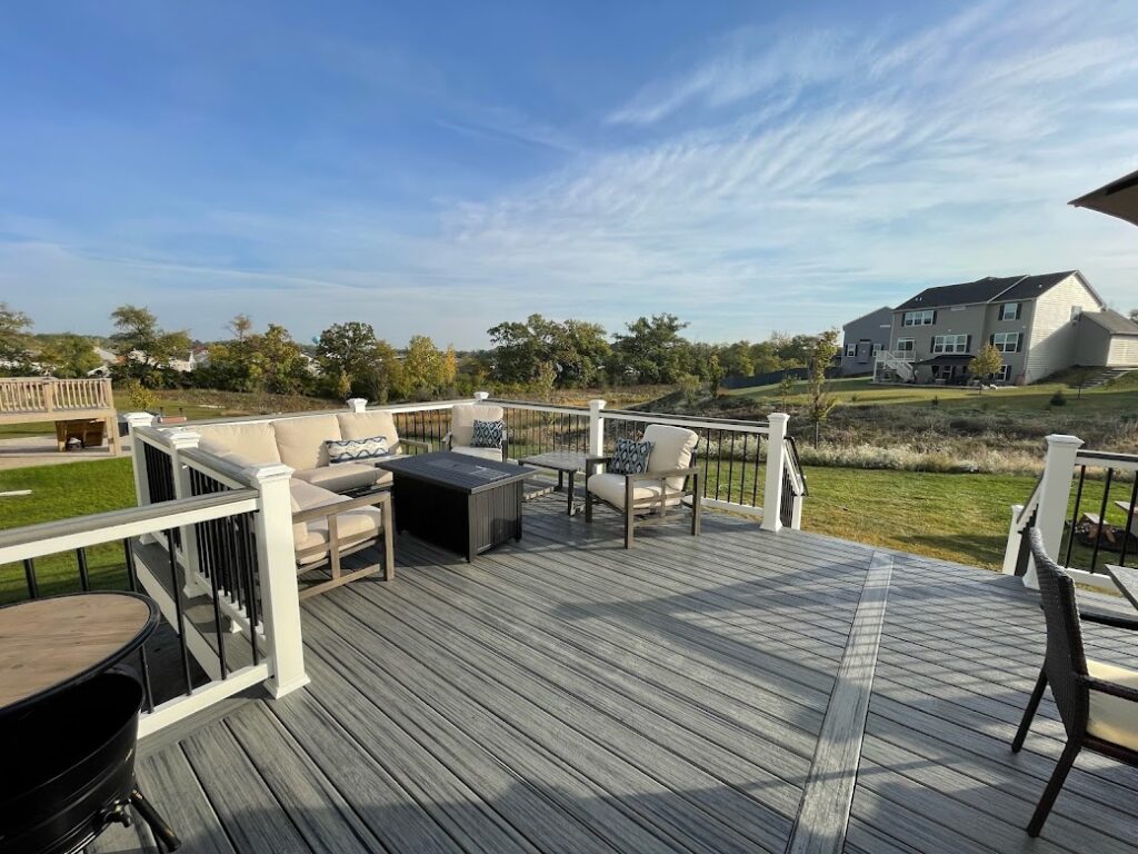 Composite deck outdoor lounge with white railing and seating area installed by Platinum Decking deck builder near Plainfield Illinois.