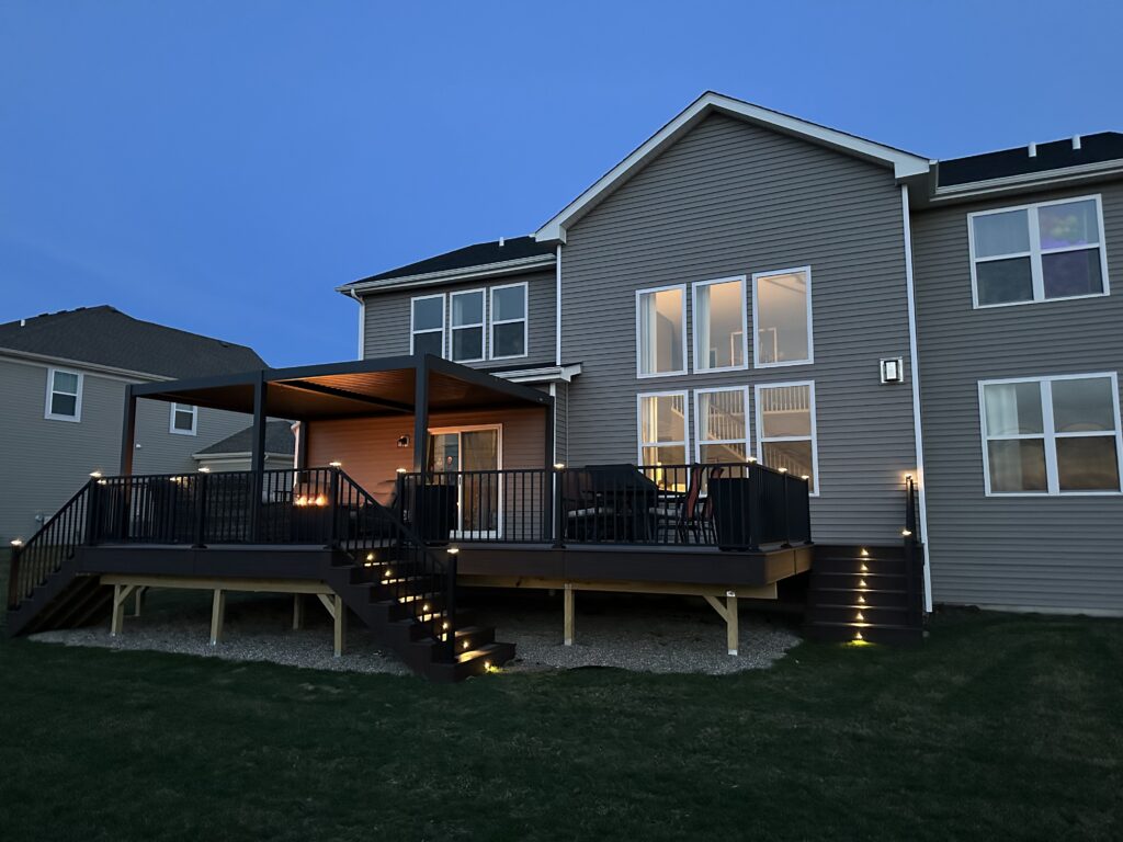 Modern composite deck with pergola and LED stair lighting built by Platinum Decking serving Plainfield IL and the Chicagoland area.