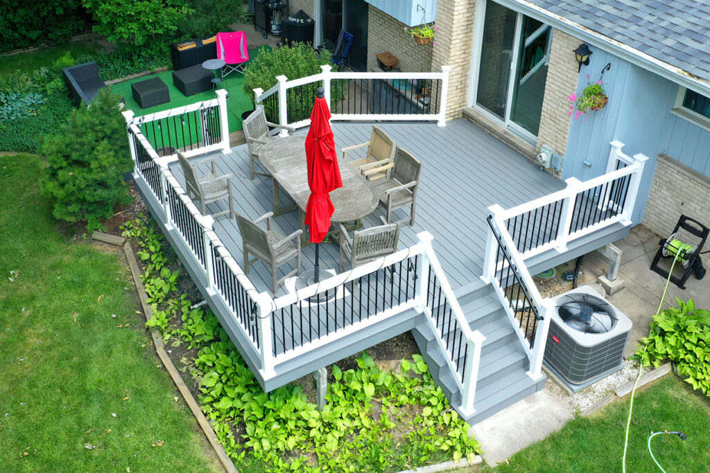 Composite deck with white railing and outdoor dining space installed by Royal Deck deck builder near Plainfield Illinois.