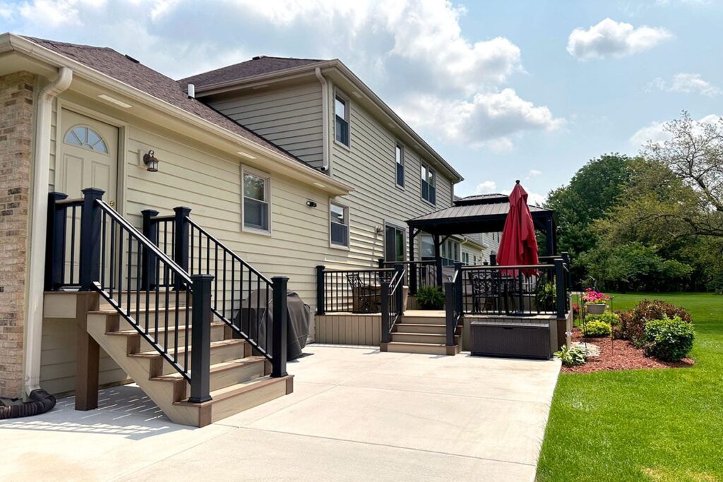 Large composite backyard deck with lounge seating and outdoor grilling area built by Royal Deck serving Plainfield IL and the Naperville area.