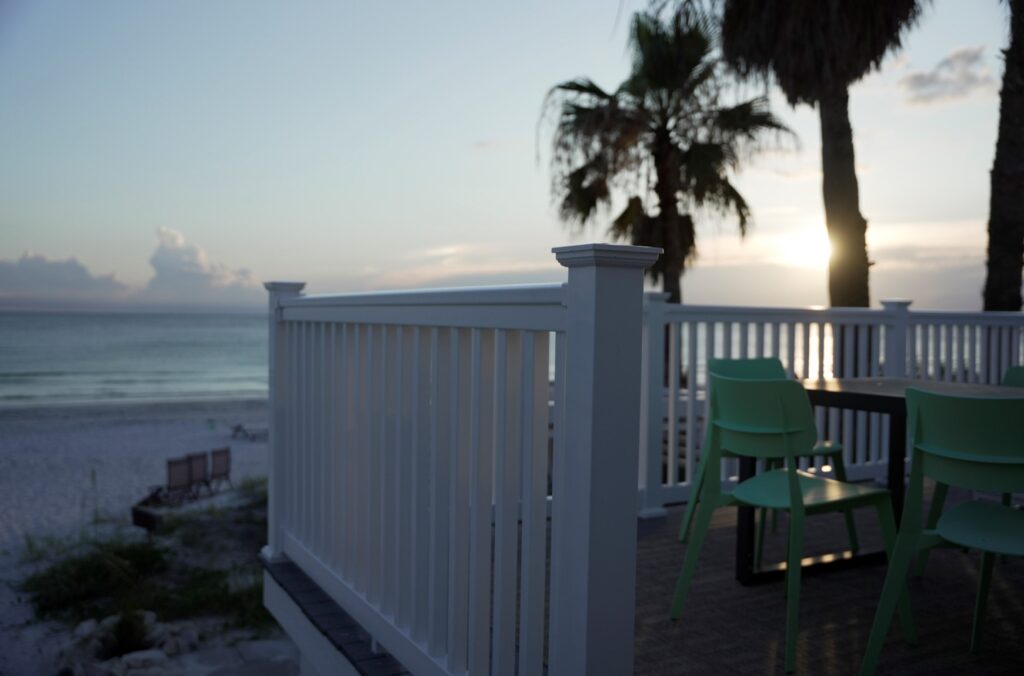 Envision Traditional composite deck railing with wood-toned top rail and black balusters, combining classic style with low-maintenance composite performance.