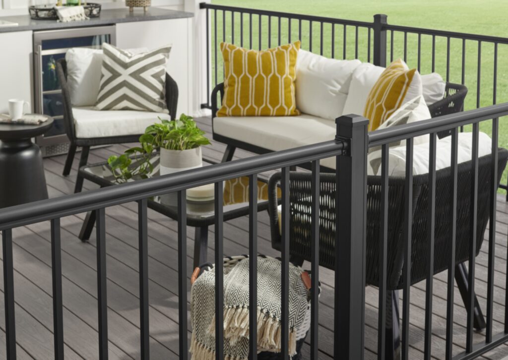 KeyLink Outlook aluminum railing installed on a residential deck overlooking landscaped greenery and open backyard space.