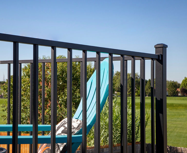 Composite deck with white railing and ocean-style view, highlighting moisture-resistant materials suitable for Midwest and variable climates.