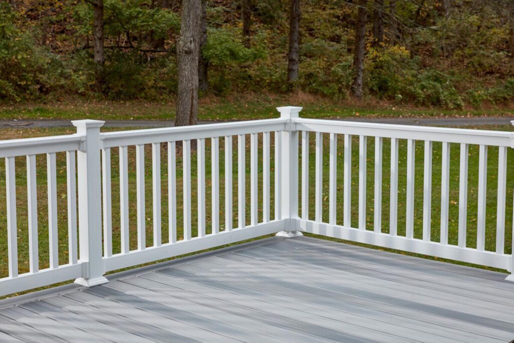 MoistureShield Traverse composite deck railing in white installed on a gray deck corner, offering a clean outdoor finish with durable, low-maintenance performance.