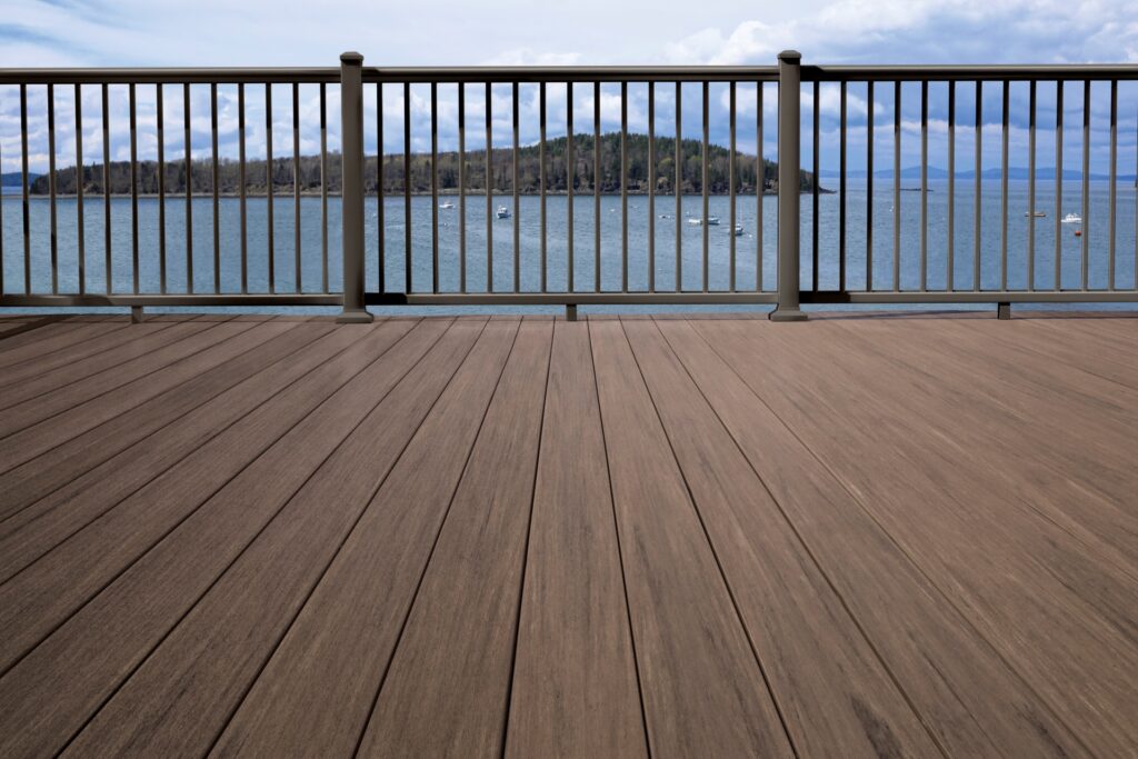 TimberTech Impression Rail Express Classic metal deck railing in bronze finish with vertical balusters on waterfront deck.