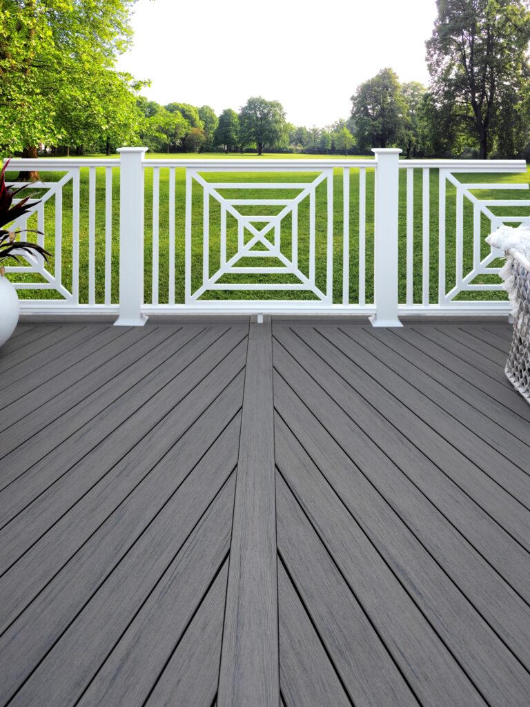 TimberTech Pinnacle Rail PVC deck railing with white frame, white balusters, and decorative geometric infill panels on gray deck.
