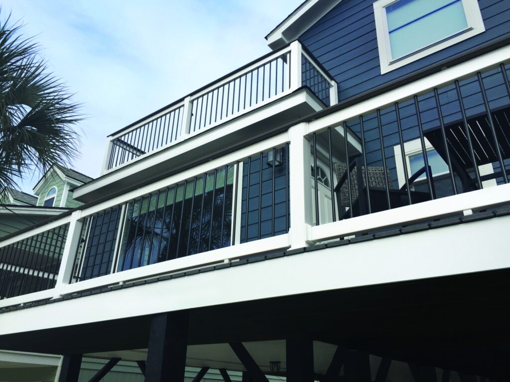 TimberTech Reliance Rail premium vinyl deck railing with white frame, black balusters, and white top rail on elevated home exterior.