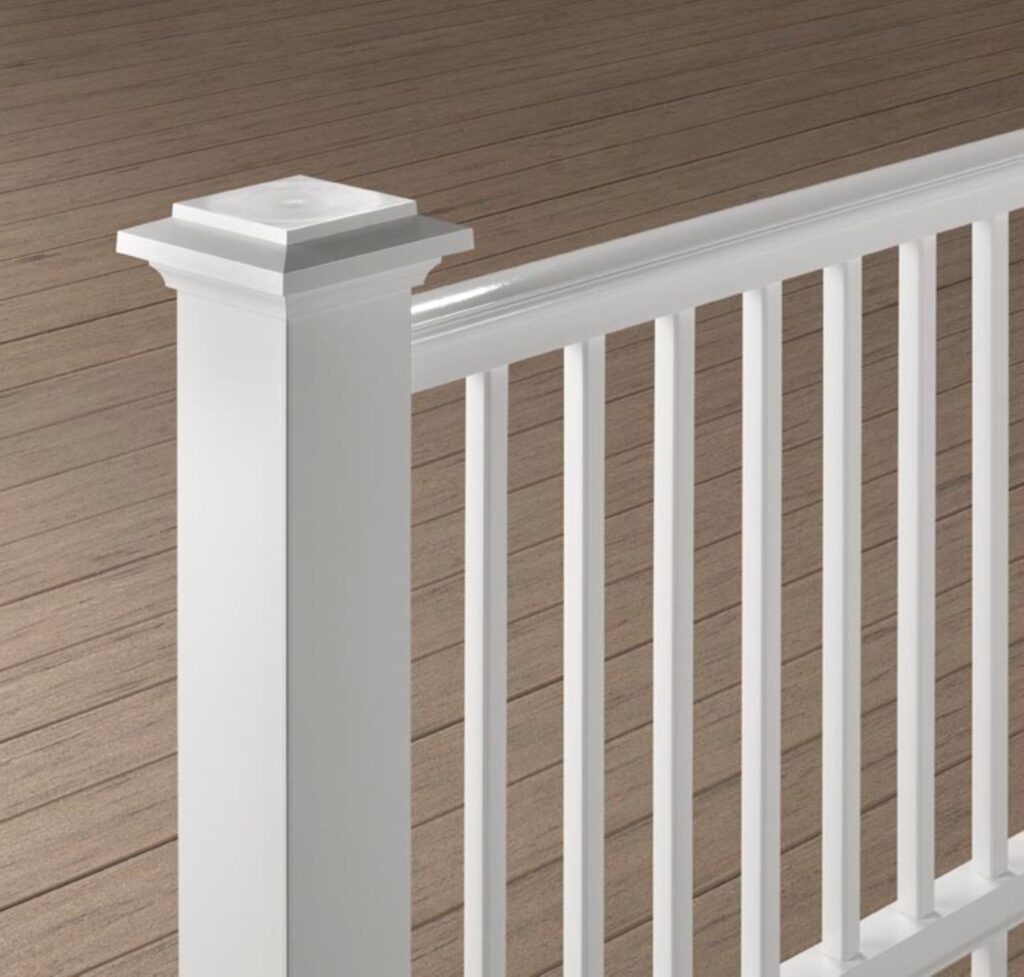 TimberTech Trademark Rail composite deck railing close-up with white post, white rails, and white balusters on brown deck