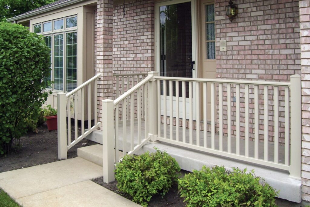 Westbury Raven vinyl porch railing in a light neutral tone installed on front entry steps, offering a clean traditional design with durable low-maintenance materials.