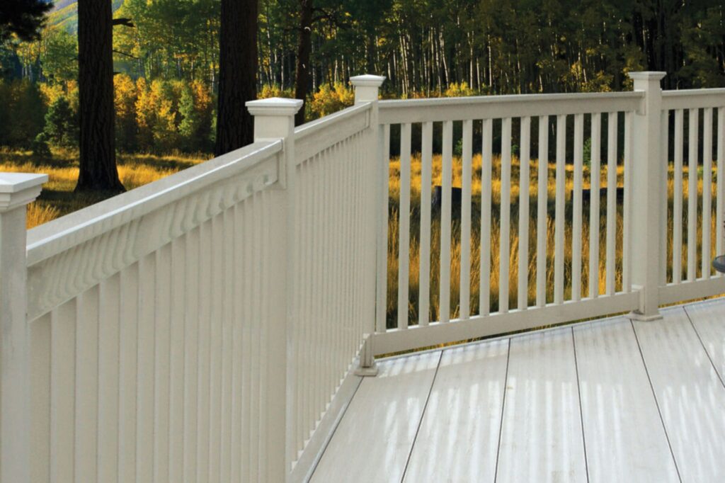 Westbury T-Bird vinyl railing in a light finish installed on a deck surrounded by natural landscape, featuring detailed top rail design and vertical balusters.