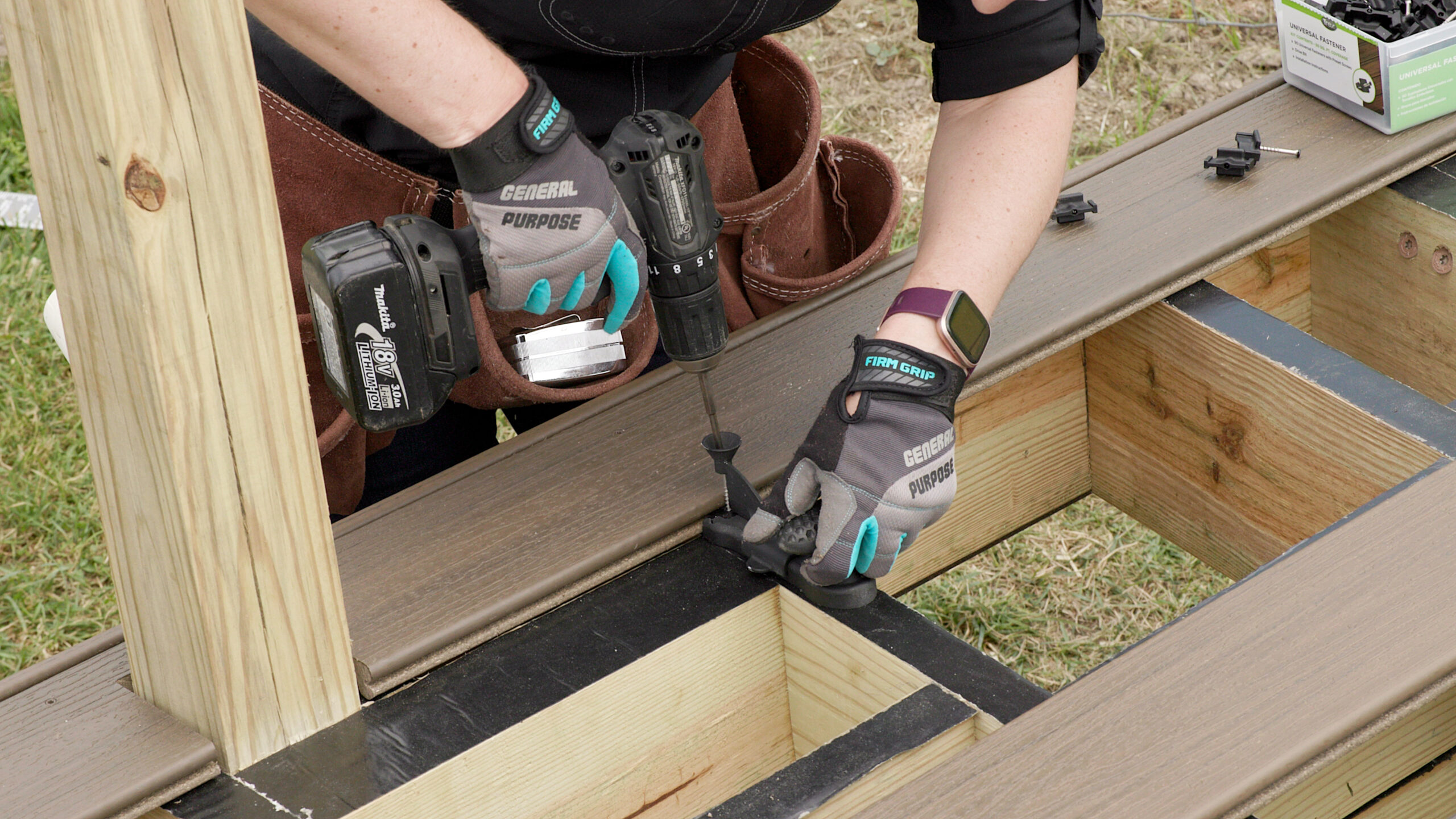 Contractor installing composite deck boards with hidden fasteners per 2024 IRC composite decking code requirements