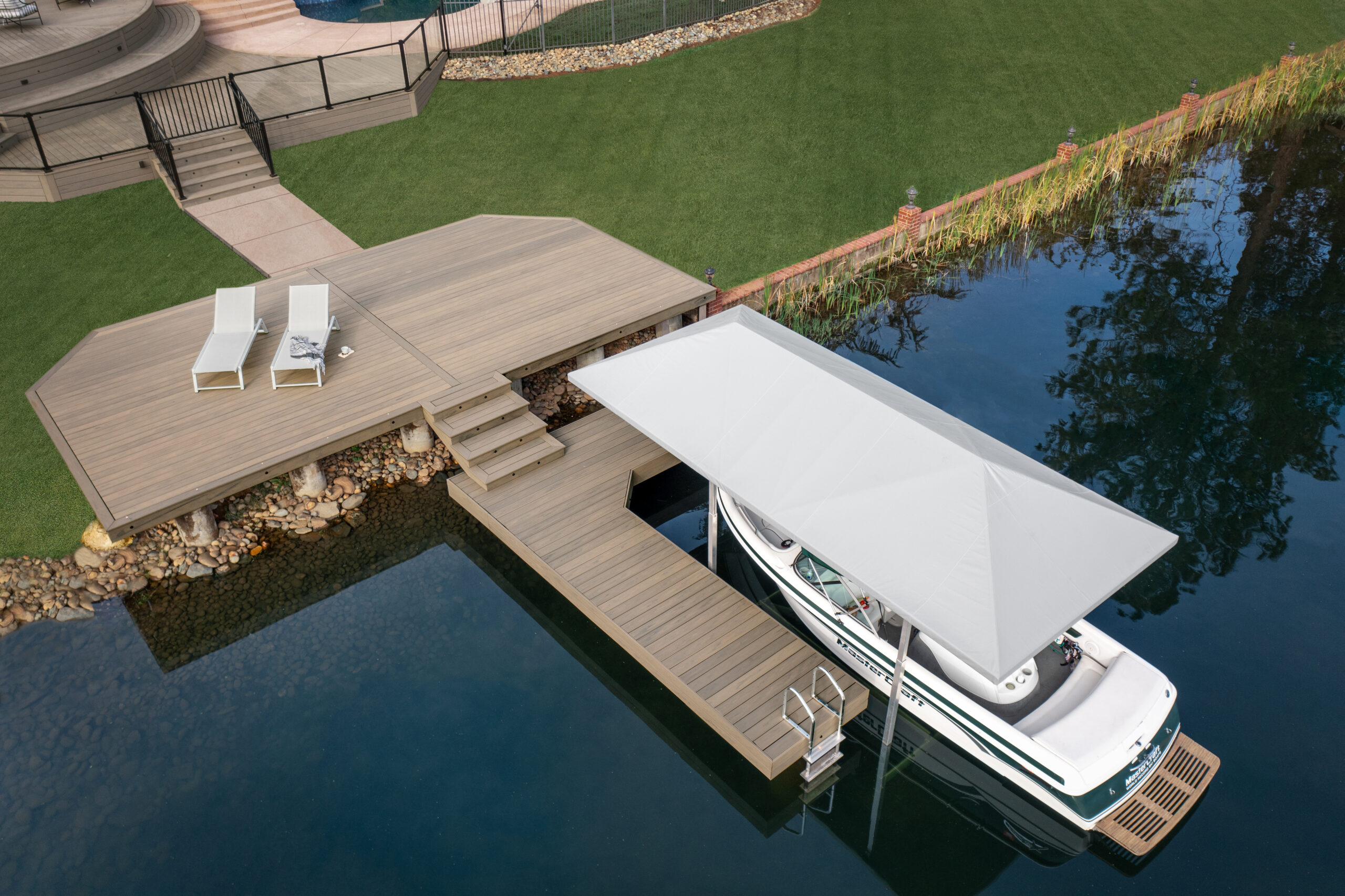 decks vs docks – covered dock with composite decking, lounge chair, and lake view