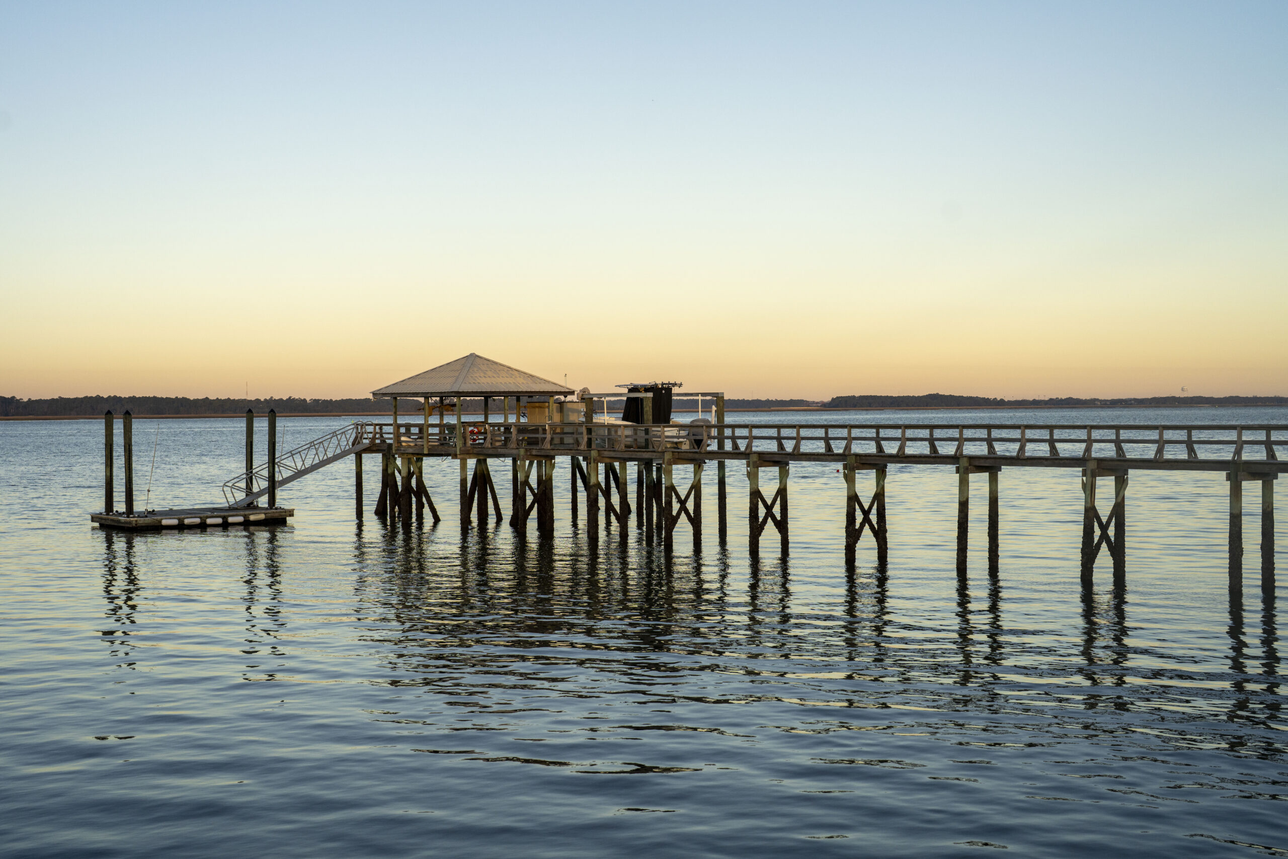 a pier floating in the middle of the water sitting on top of wooden slabs, showing the clear difference between piers vs. docks