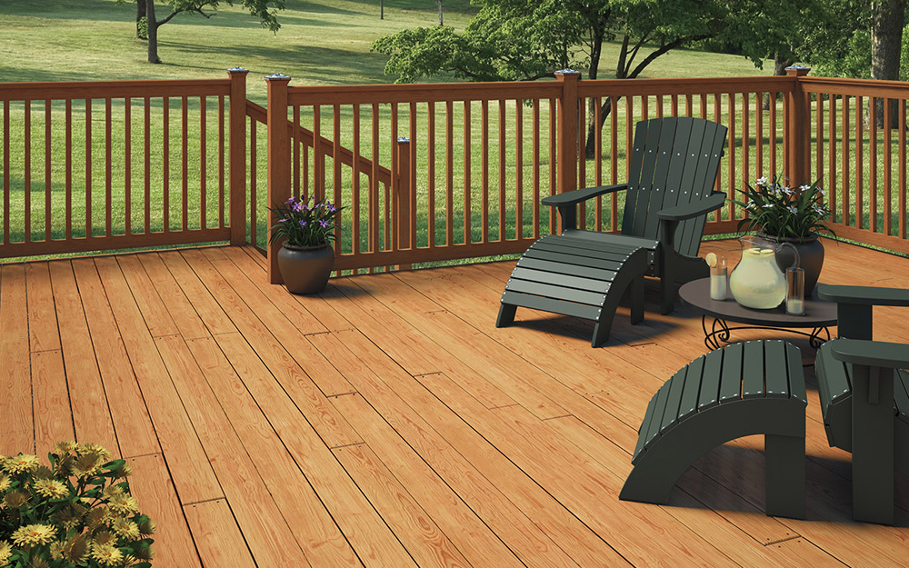 Pressure treated lumber deck with traditional wood railing and Adirondack chairs on a residential backyard deck