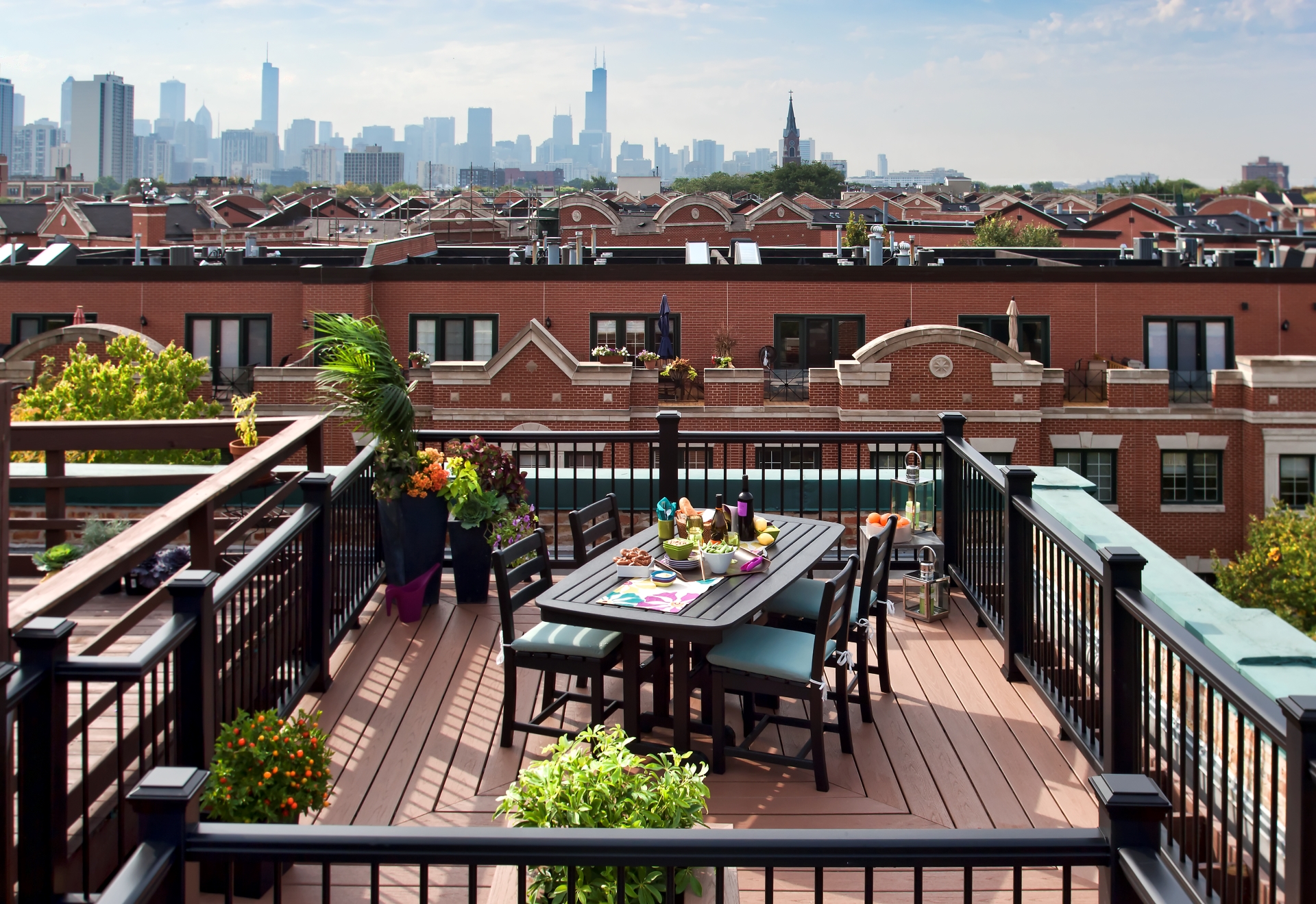 Composite decking on a Chicago rooftop deck with picture-frame border, black railing, and dining set overlooking the skyline.