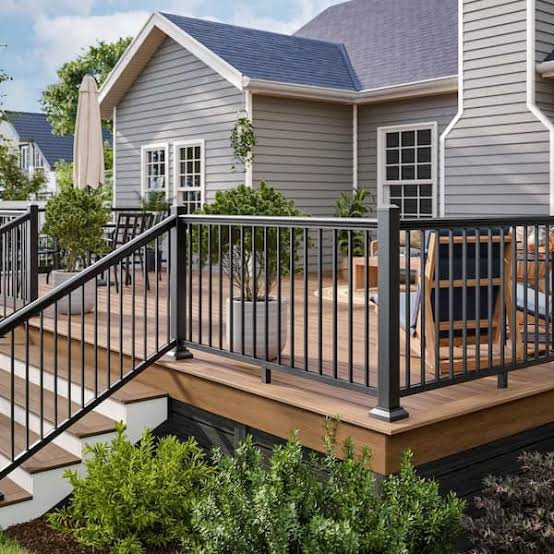 Elevated deck with stairs, step lighting and white guardrail system built to 2024 IRC handrail and guardrail code requirements