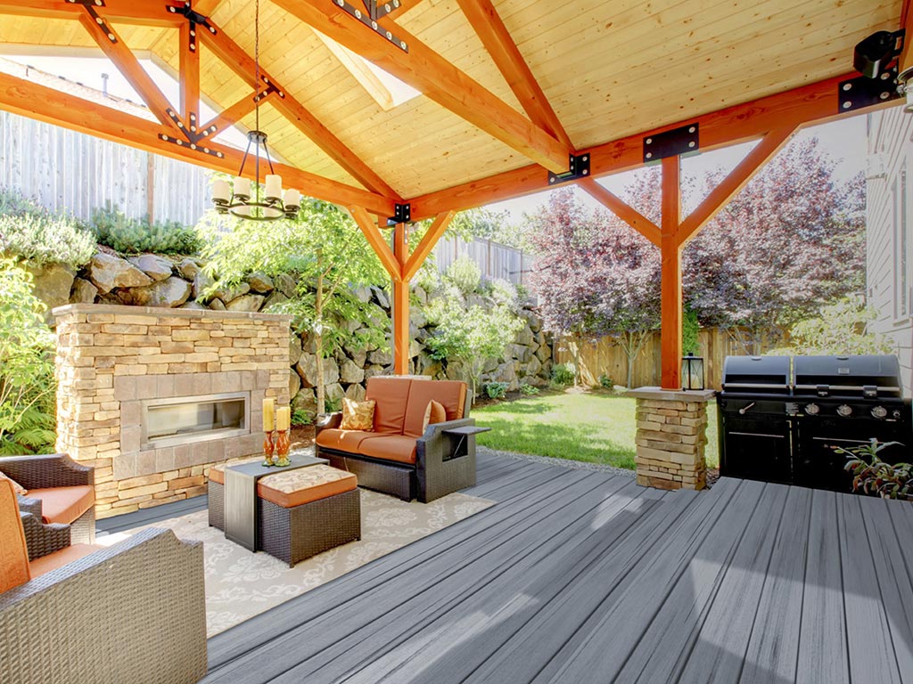 MoistureShield Elevate Alpine Gray composite deck under covered patio with stone fireplace and grill