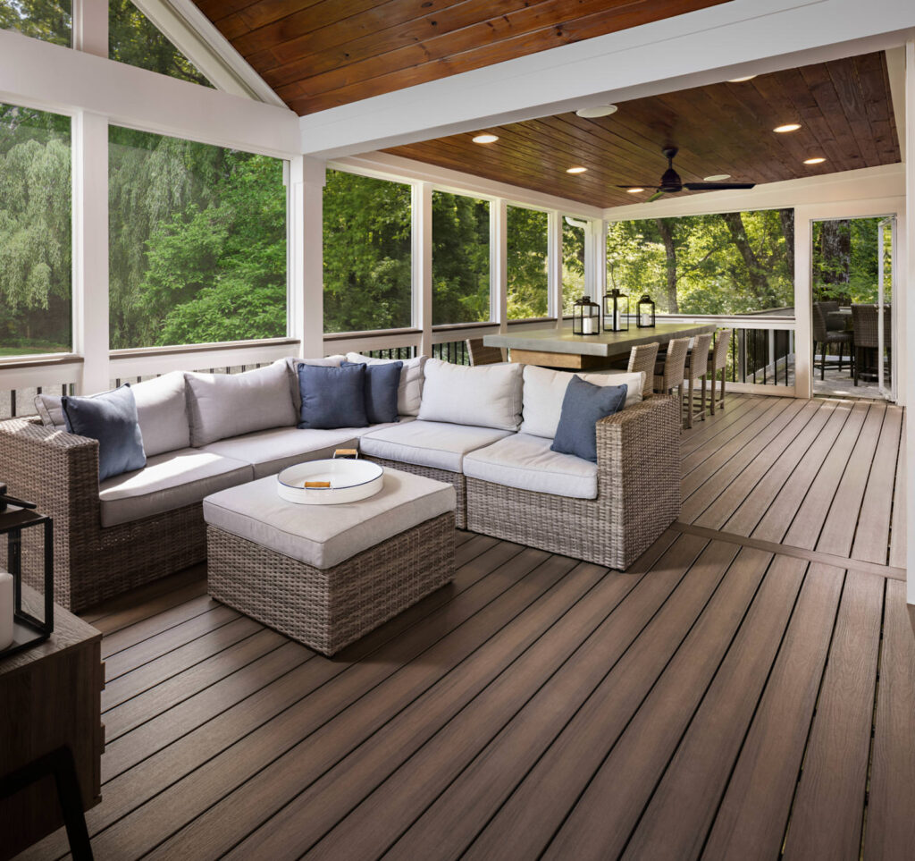 MoistureShield Elevate Riverbank composite deck screened porch with wicker sectional and dining area