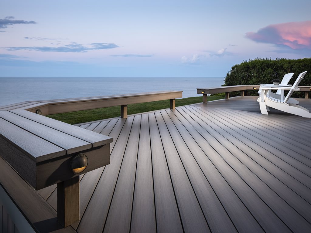 MoistureShield Meridian Citadel composite deck with built-in bench seating overlooking ocean at dusk