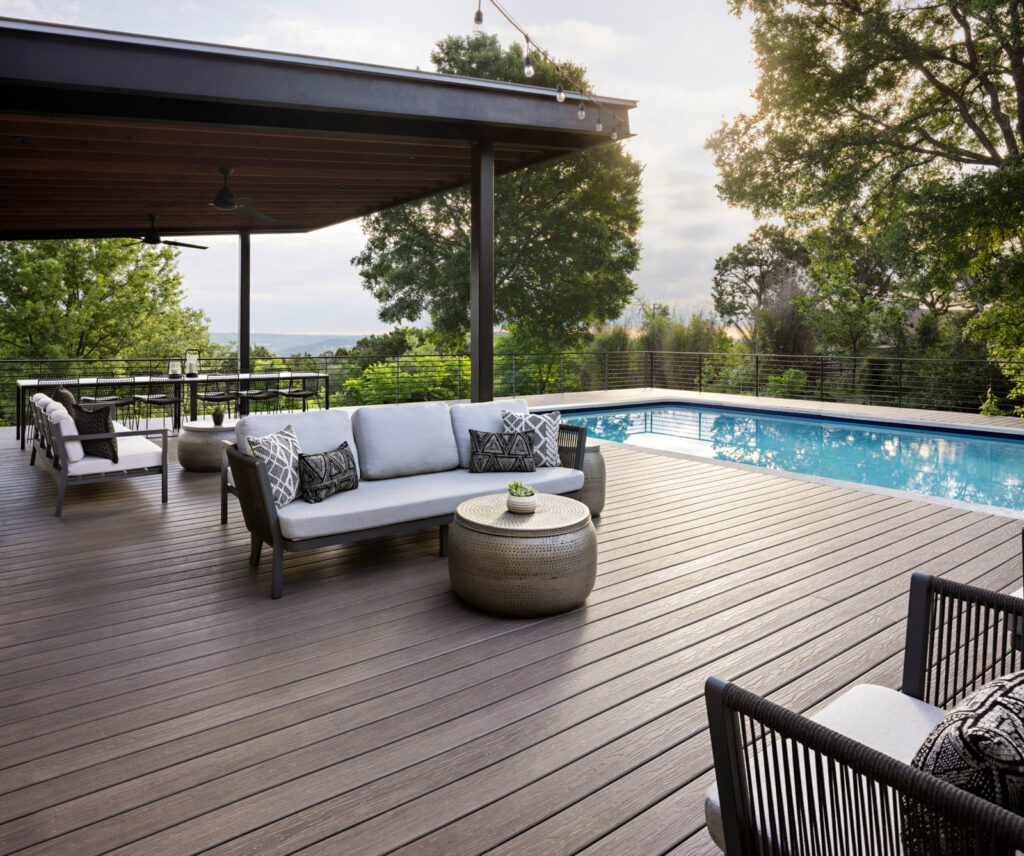 MoistureShield Vision Cathedral Stone composite deck with poolside seating area and covered pergola