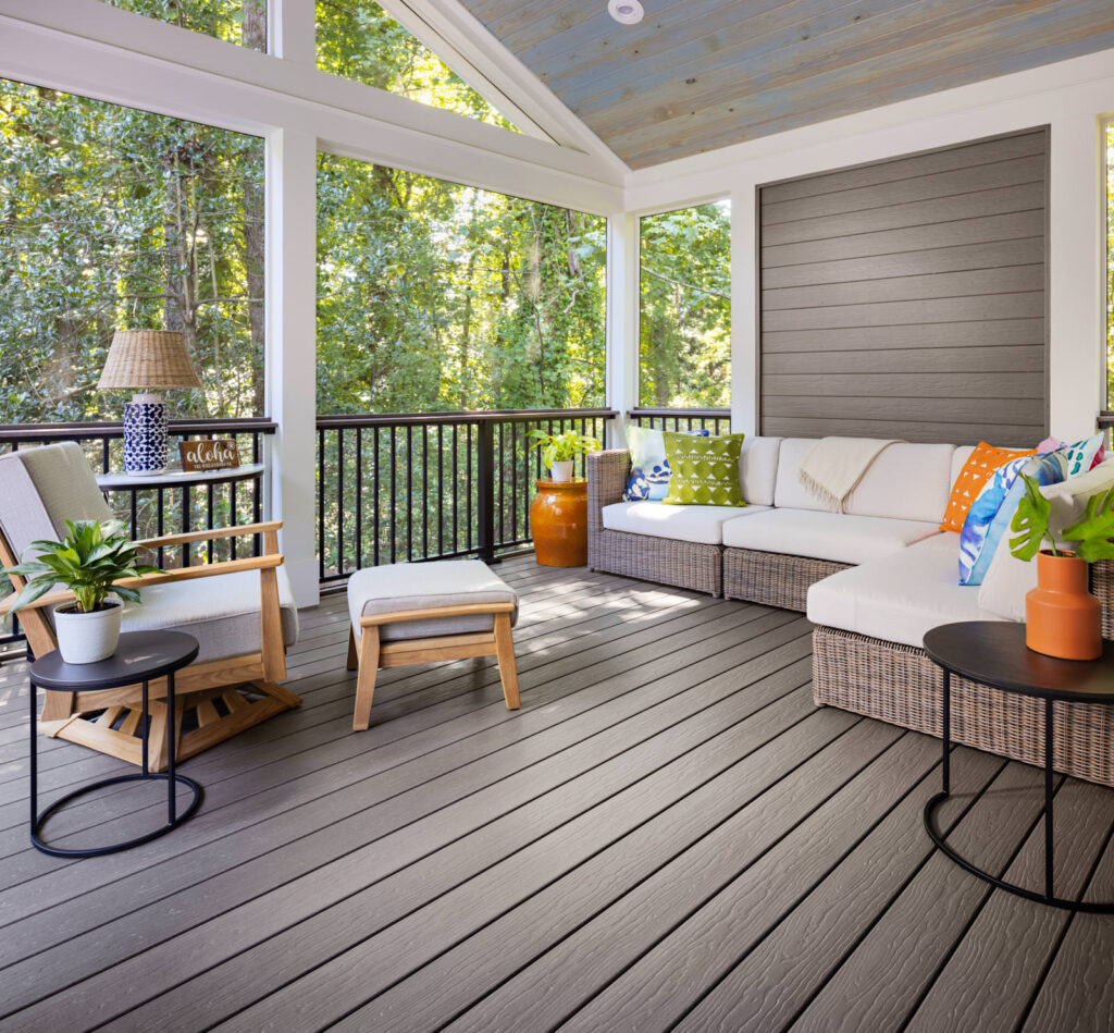 MoistureShield Vision Cathedral Stone composite deck on screened-in porch with wicker outdoor furniture