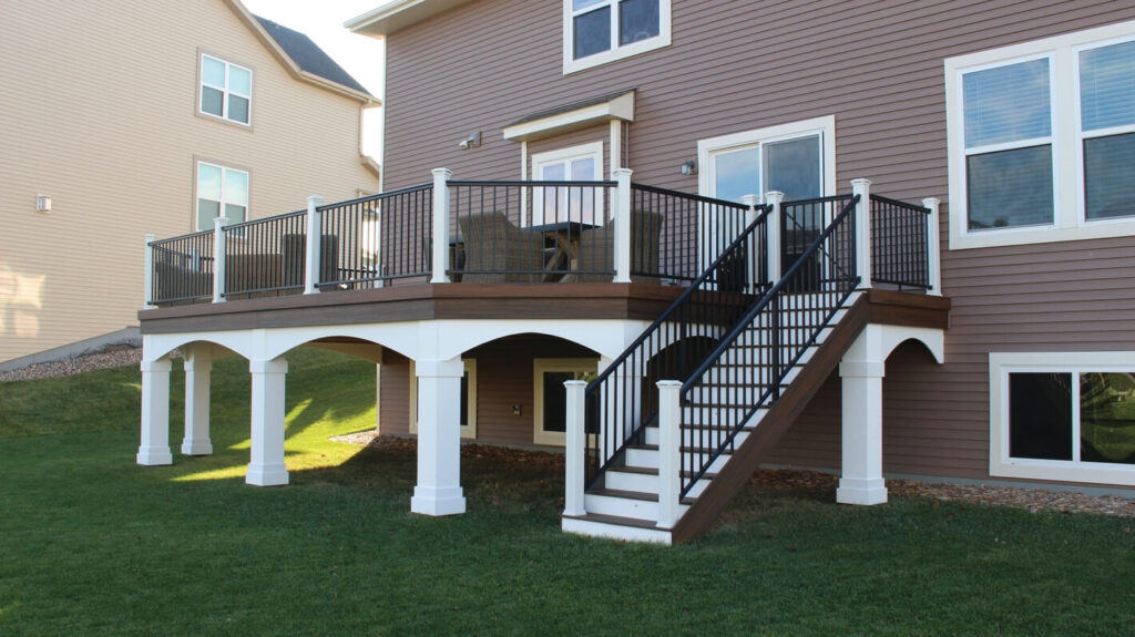 AFCO Series 100 black aluminum railing with narrow balusters on a lakeside composite deck, modern metal deck railing ideas.